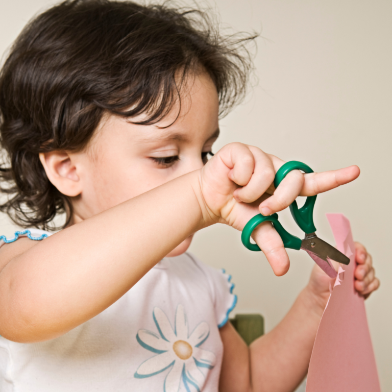 Enfant utilisant des ciseaux lors d’une activité de découpage